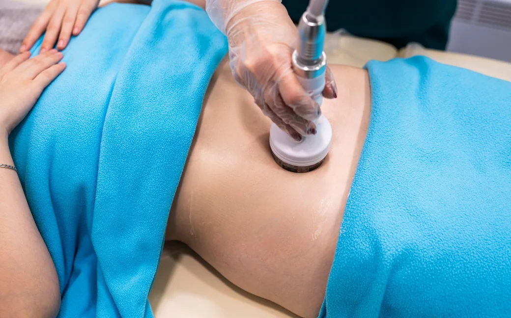 Therapist performing a body contouring treatment on the stomach