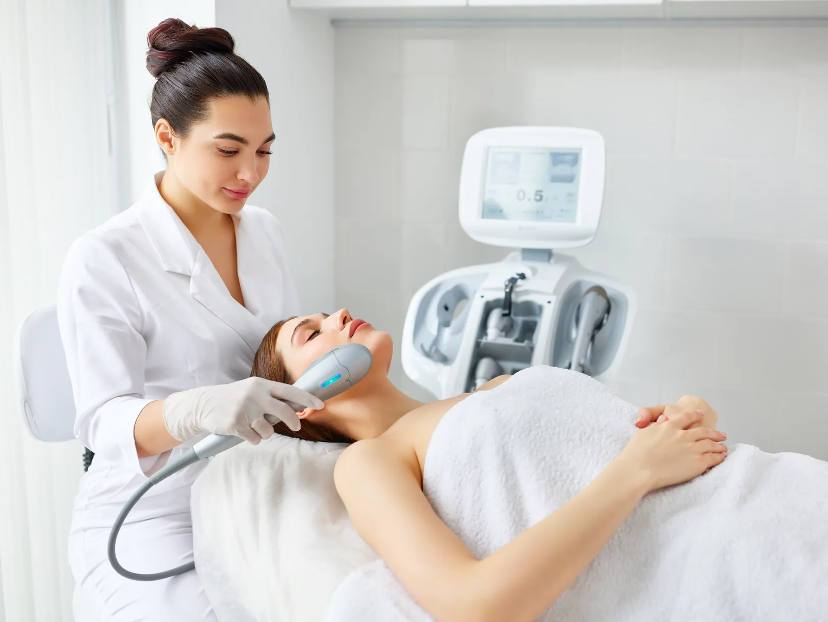 Therapist performing a facial treatment with an RF device
